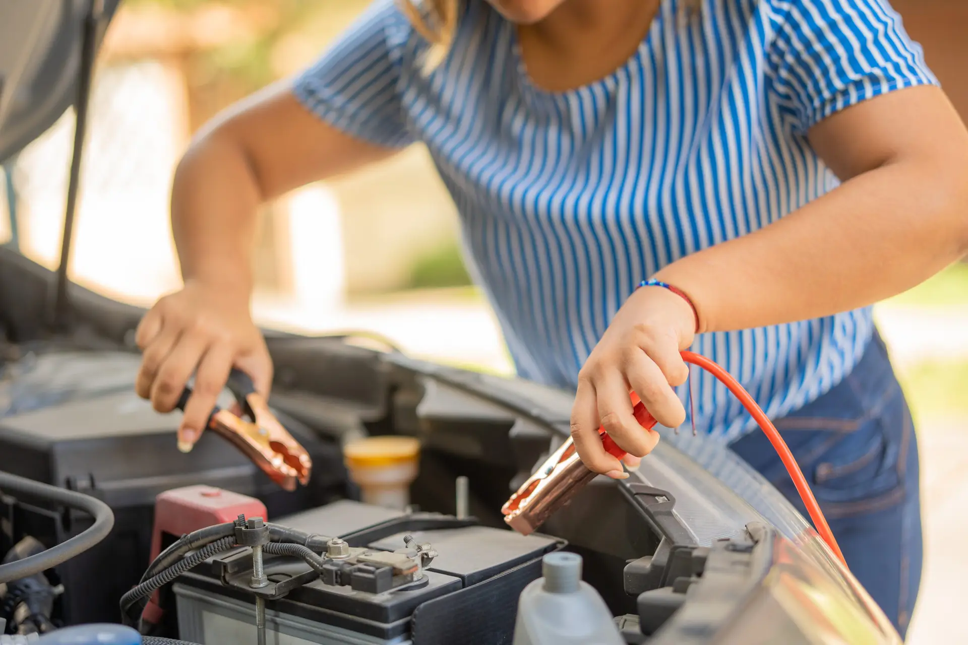 a lady attaching wires for jump start the vehicle